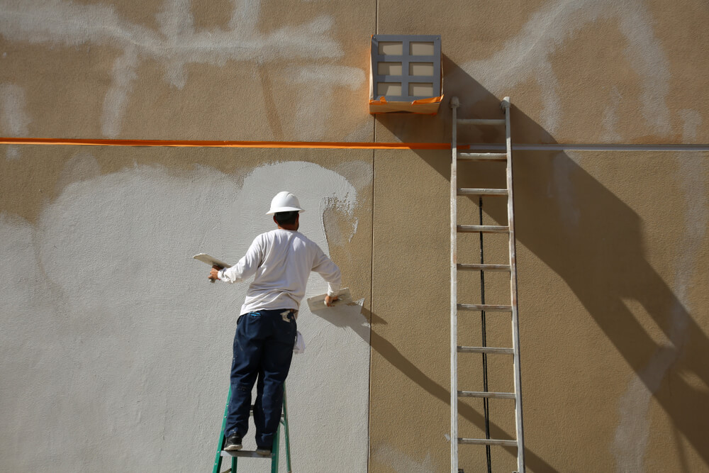 Stucco,On,A,Building,Wall.,An,Unidentifiable,Contractor,Applies,Stucco