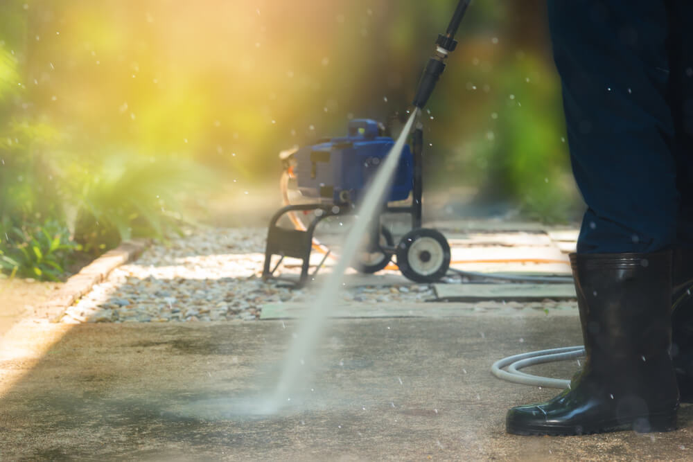 Worker,Cleaning,Pathway,With,High,Pressure,Washer,Splashing,The,Dirt